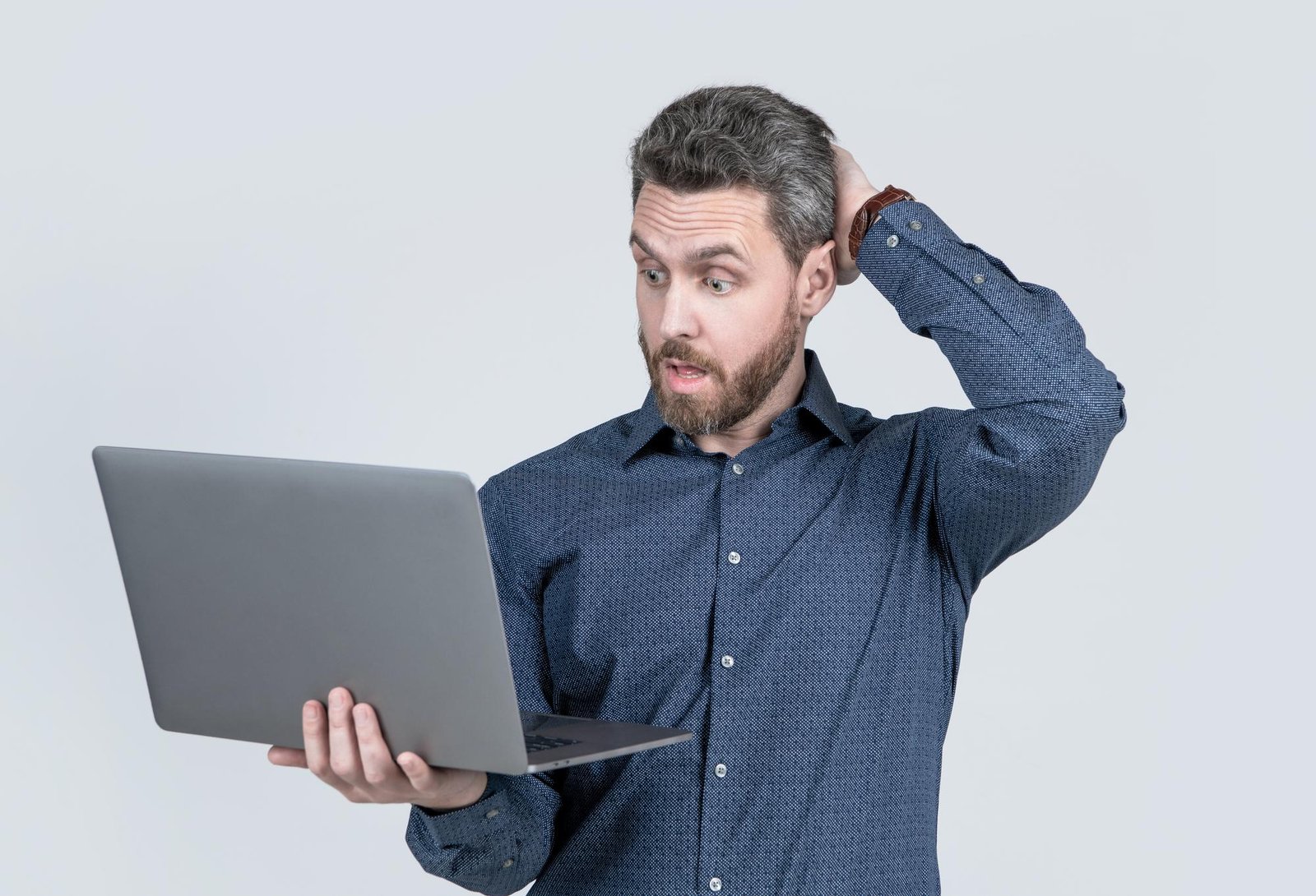 A confused man holding a laptop and scratching his head while looking at the screen. This photo shows the exact feeling when a brand paid for professional design but still feels cheap, unprofessional, or outdated online. Featured image for the blog post 'Why Your Brand Feels Cheap Online (Even When You Paid for Design)